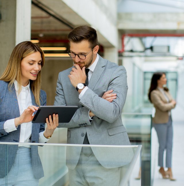 Two business people looking at a tablet in an office on the D&J Consultants Site