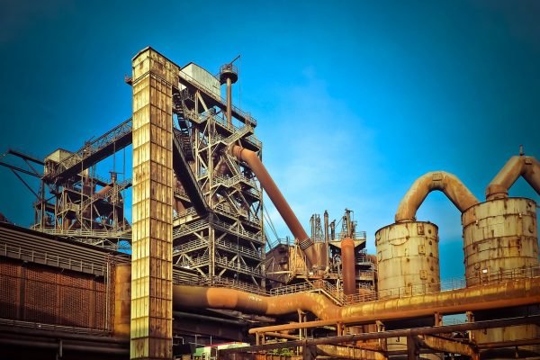 An industrial plant with pipes and a blue sky