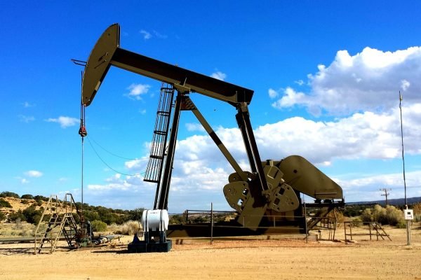 An oil pump in the desert under a blue sky.