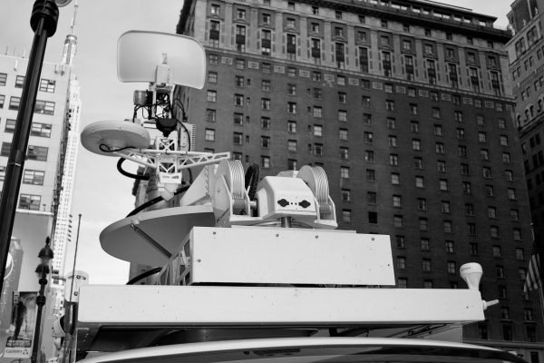 A black and white photo of a radio tower on top of a car representing Technology, Media & Telecommunications.